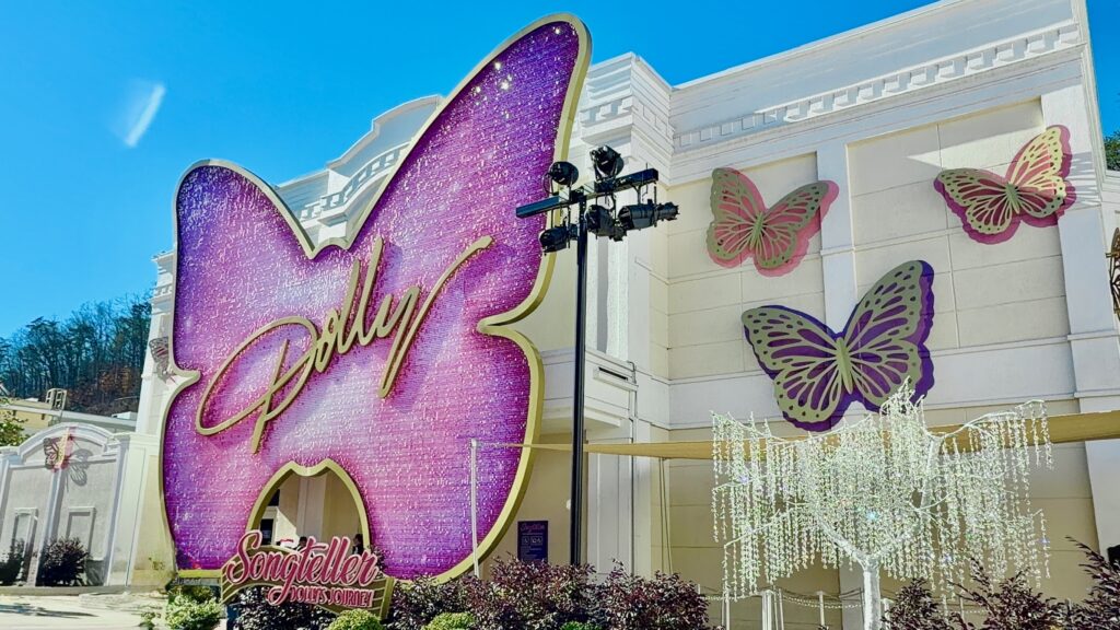 The Dolly Parton Experience Exterior The Dolly Parton Experience at Dollywood exterior that features a large ombre purple butterfly with sparkling reflectors with three similar butterflies.