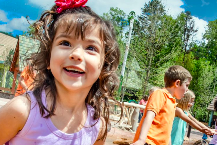 Wildwood Creek at Dollywood play area with children enjoying the pop-jet water features and instruments.