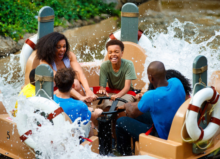Smoky River Mountain Rampage Dollywood attraction with a family raft crashing through whitewater rapid